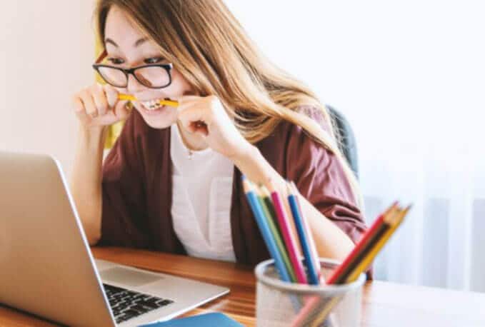 A girl is writing on the laptop.